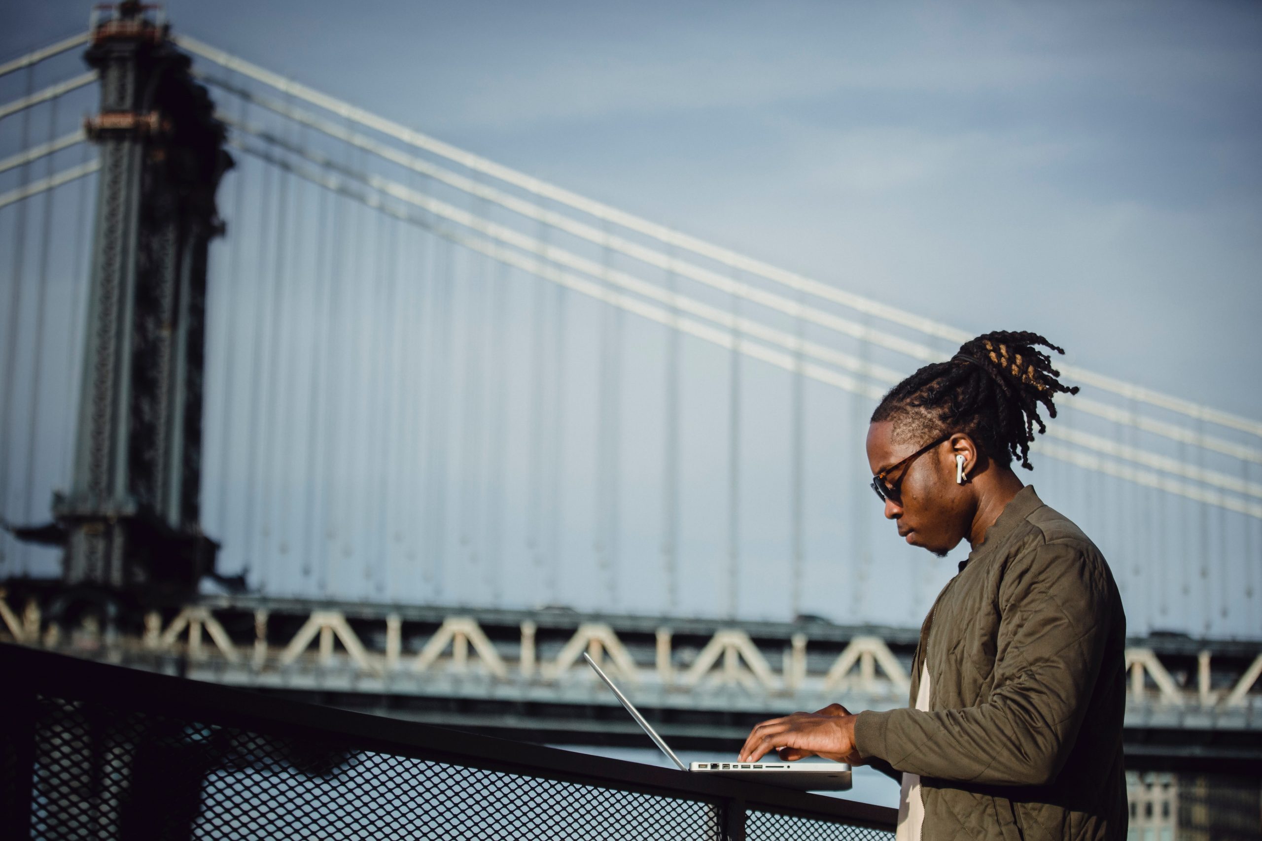 man-at-laptop-by-bridge