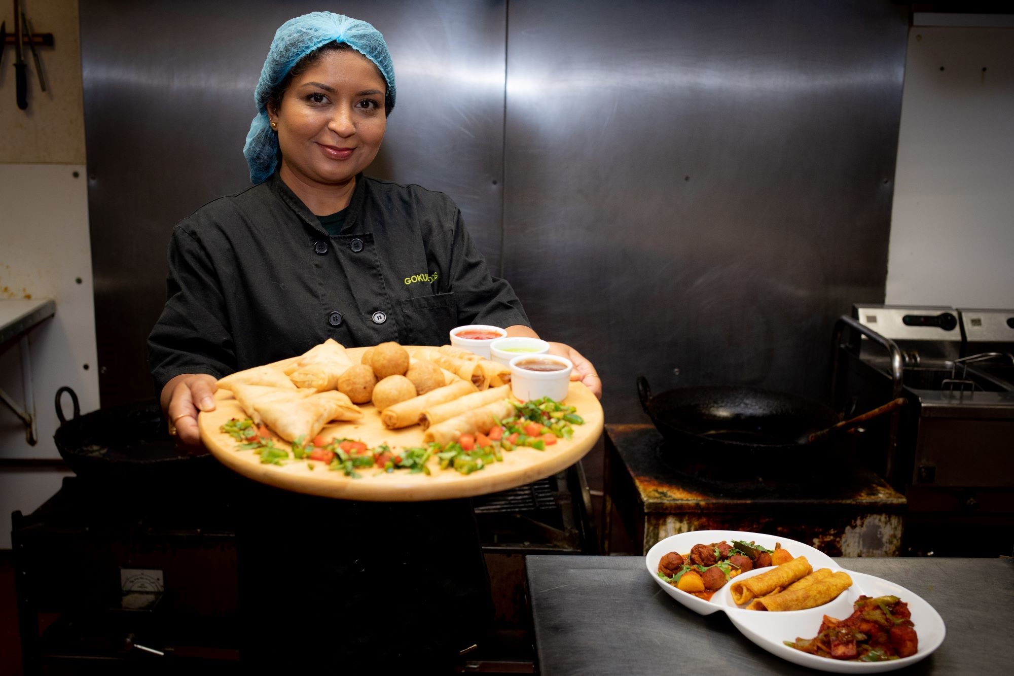 Lady holding a range of indian food 
