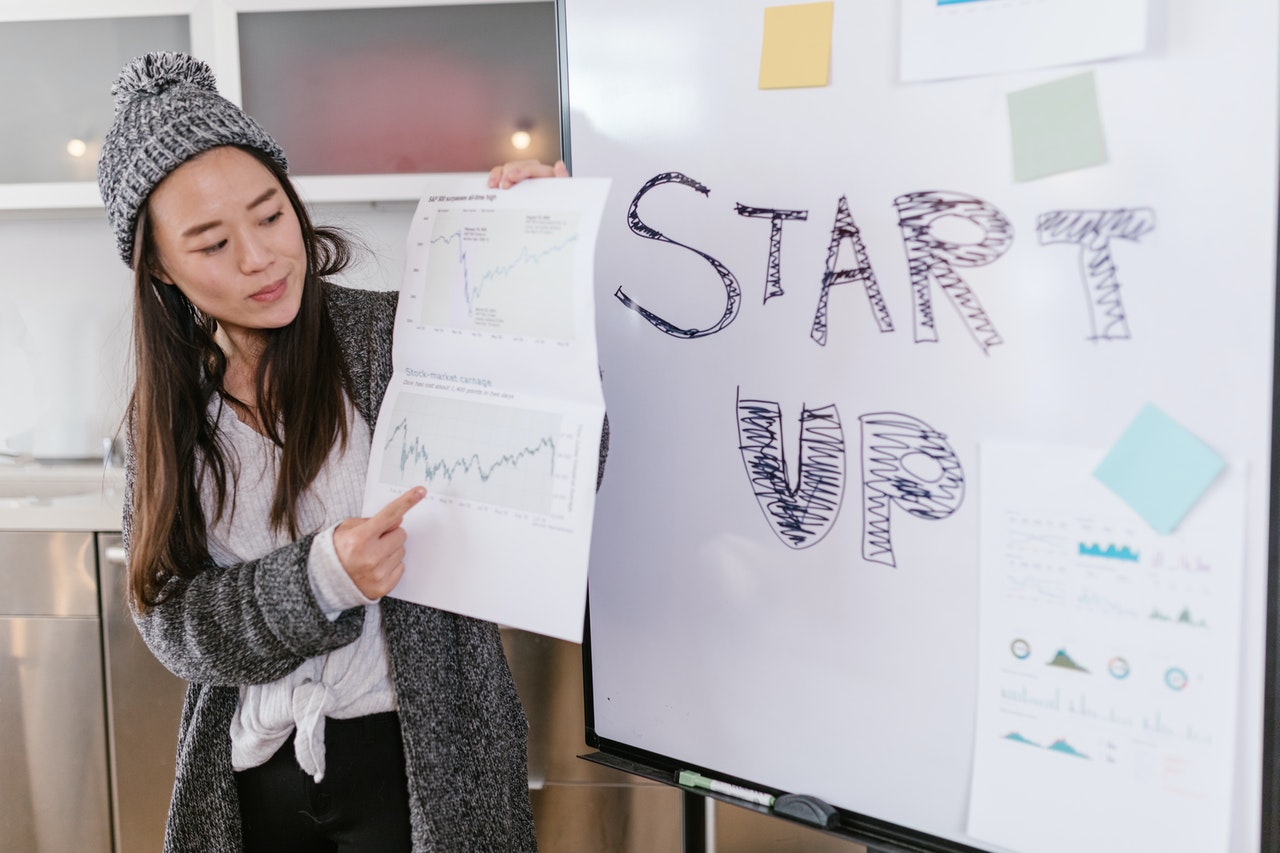 female-presenting-whiteboard-with-startup-words 