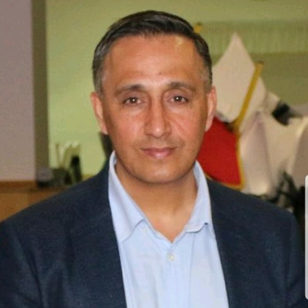 An Asian man in blue shirt and dark jacket