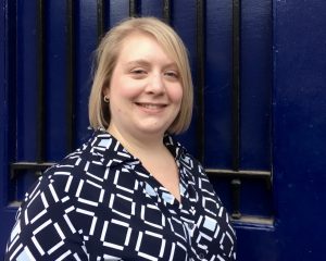 female in front of blue door