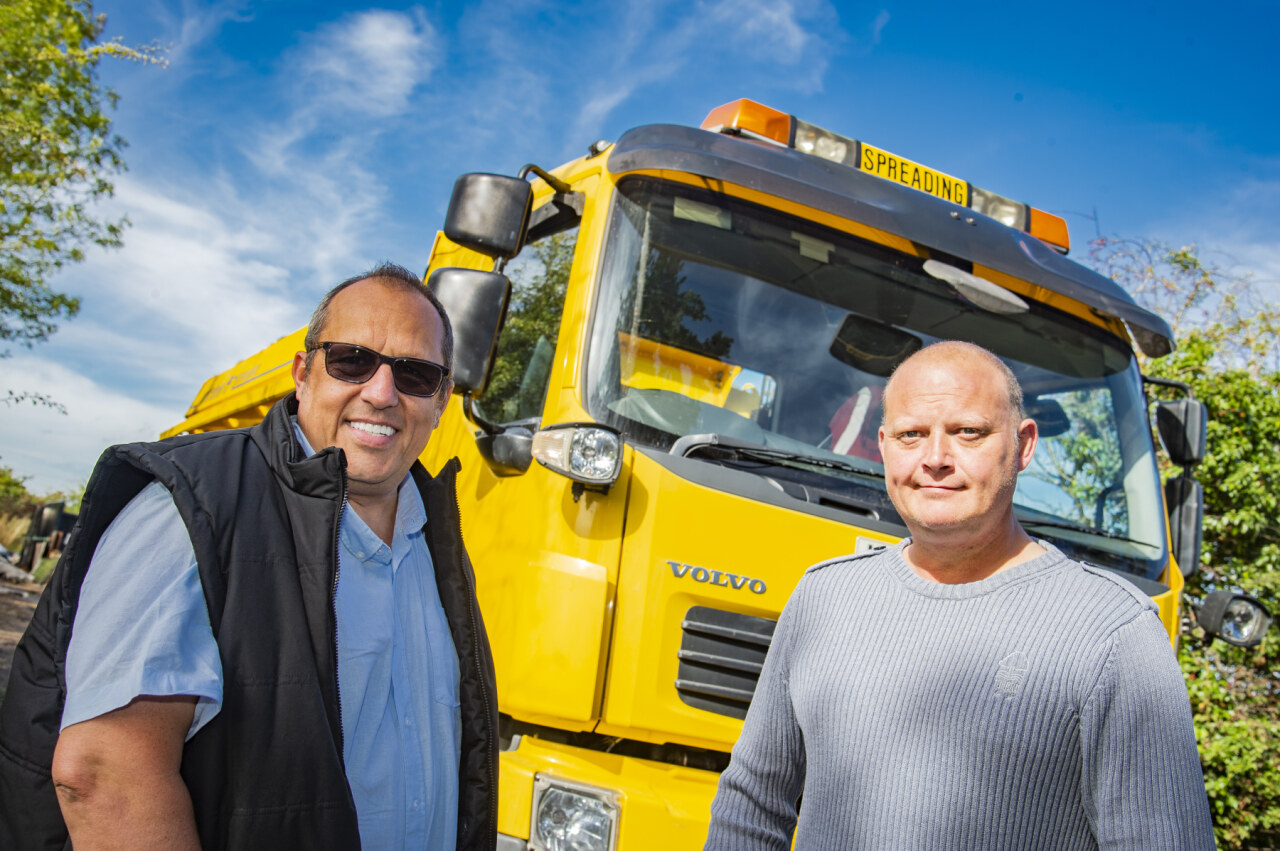 Image of two men in front of gritting truck